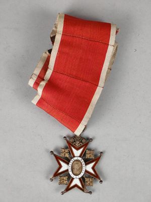 une image représentant une médaille ornée d'un ruban rouge et d'une étoile