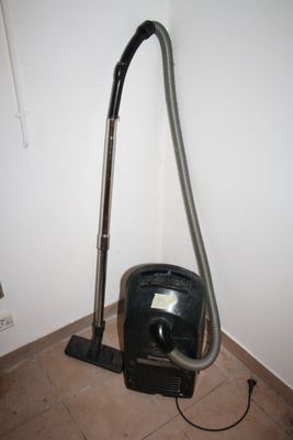 a vacuum that is sitting on the floor next to the wall