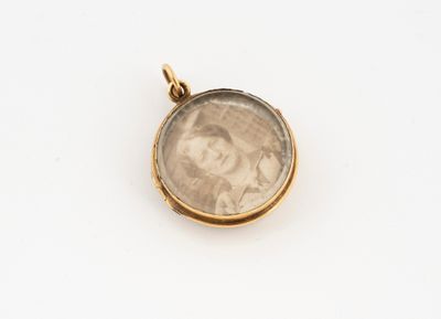 a close up of a gold pendant with a picture of a woman