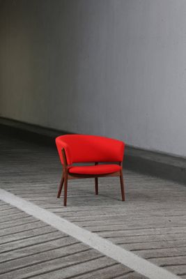 une chaise rouge qui se trouve au milieu d'une pièce