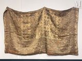 a gold cloth hanging on a wall in a room
