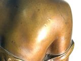 a bronze statue of a woman with a flower in her hair