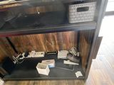 a black shelf with electronics on it in a room