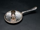 a silver plate with a spoon on it on a black surface