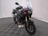 une moto qui est garée dans une pièce dont le sol est en damier