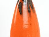 an orange vase that is sitting on a white surface