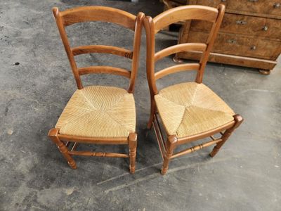 deux chaises en bois assises l'une à côté de l'autre sur le sol