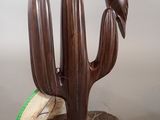 a wooden sculpture of a cactus with a bird on it