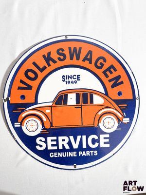 un panneau orange et bleu sur lequel on peut lire « Volkswagen Service – Pièces d'origine »