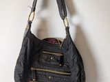 the black purse is hanging on a hook on the wall