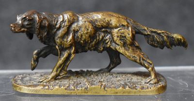 statue of a golden retriever dog running on a gray surface