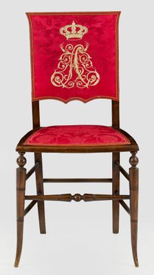 red and gold chair with a crown on the back of it