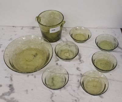 neuf verres et un pichet posés sur une table en marbre