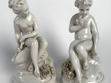 paire de figurines en porcelaine blanche représentant un garçon et une fille assis sur un rocher