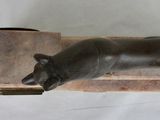 a statue of a cat laying on top of a wooden block