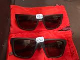 deux paires de lunettes de soleil posées sur un sac rouge