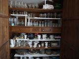 un placard rempli de vaisselle et de verres dans la cuisine