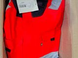 a red jacket in a cardboard box with a tag on it