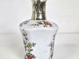 une image représentant une petite bouteille en verre ornée de fleurs