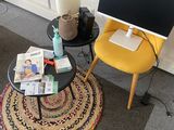 a small table with a computer on it in the corner of a room