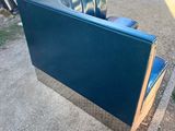 a blue couch sitting on the side of the road