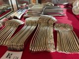 a lot of silverware on a red table