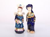 two figurines of a man and a woman standing next to each other