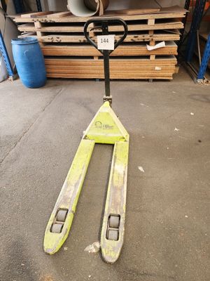 un chariot élévateur posé au sol dans un entrepôt