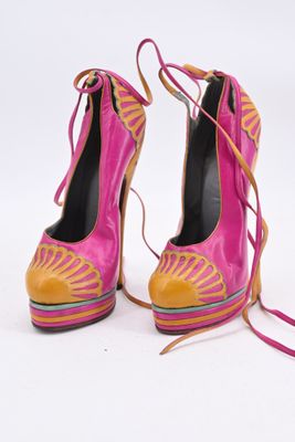 une paire de chaussures à talons hauts roses et jaunes, dotées de lacets