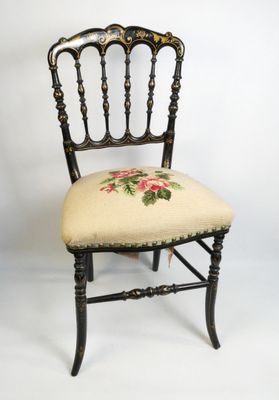 une petite chaise dont le dossier est orné d'un motif floral