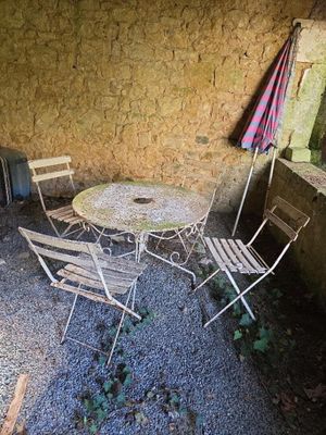 terrasse en gravier avec table, chaises et parasol, dans un cadre extérieur