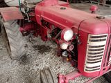 a red tractor that is parked in a garage