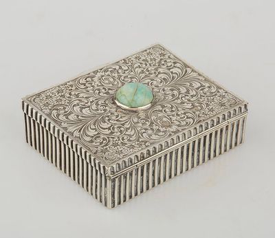 an antique silver box with a turquoise stone in the center