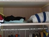 a closet with clothes and other items on the shelves