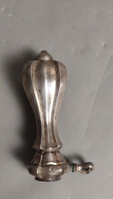 a silver object on a table with a chain