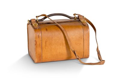 valise en cuir marron sur fond blanc, avec une découpe pour la sangle