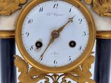 a gold and black clock with a bird on it