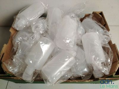 une boîte remplie de bouteilles en plastique posée par terre