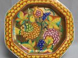 une assiette décorative sur laquelle est représenté un grappe de raisin