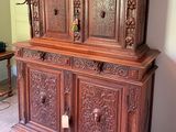 a large wooden cabinet with carvings on the top of it