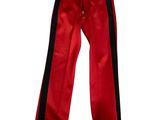 Le pantalon est rouge et noir, avec des rayures noires.