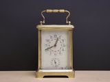 a small clock sitting on a table with a black background