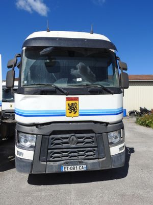 un camion blanc orné d'une bande bleue, garé sur un parking