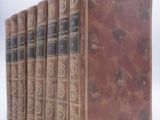 four old books sitting on top of each other on a white surface