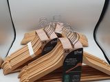 three wooden clothes hangers on display in front of a white backdrop