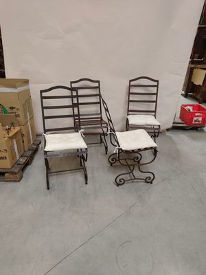 trois chaises et une table dans une pièce où il y a des cartons par terre