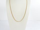 a gold chain necklace on a mannequin head