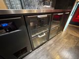 a stainless steel counter top with two glass doors