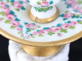 a white and gold plate with pink flowers on it