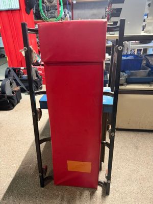 un réfrigérateur rouge posé sur un chariot dans un magasin